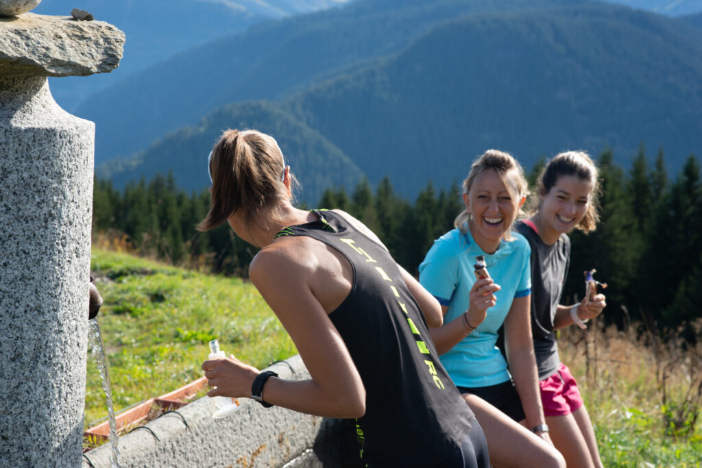 Trois randonneuses font une pause devant un bassin, pendant leur balade en Beaufortain.