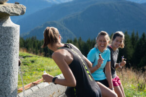 Trois randonneuses font une pause devant un bassin, pendant leur balade en Beaufortain.